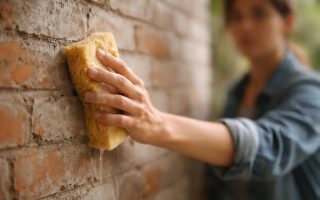 main-eponge-mur-briques-ciment