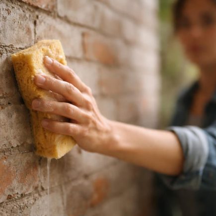 main-eponge-mur-briques-ciment